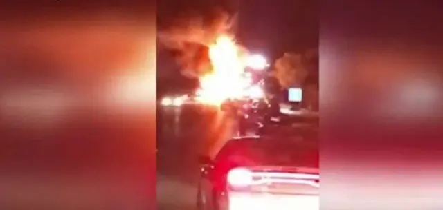 Car explosion with large flames at night.