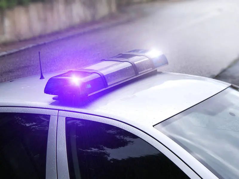 Police car with flashing blue emergency lights.