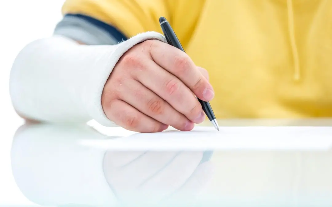 Person with arm cast writing on paper.