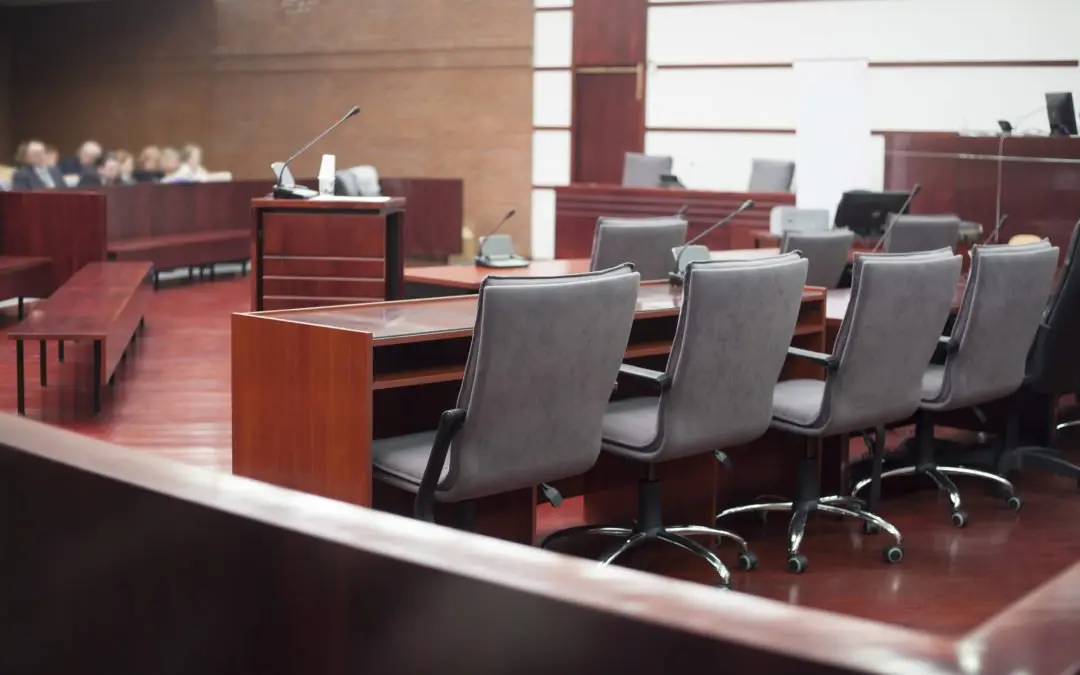 Empty courtroom with chairs and desks visible.