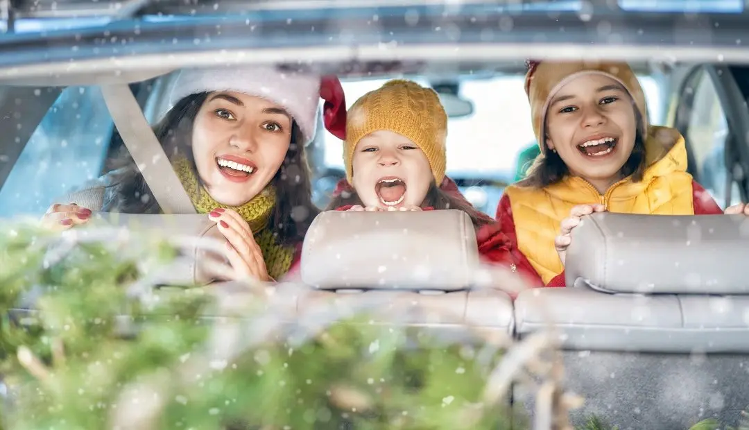 Family smiling and celebrating Christmas in car.