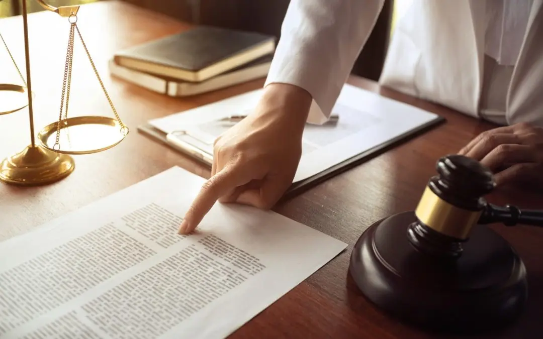 Lawyer pointing at document with gavel nearby.