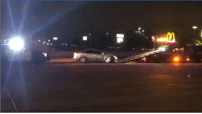 Police and tow truck assisting disabled vehicle.