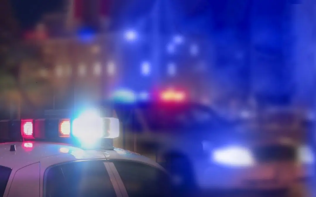 Police car with flashing lights at night.