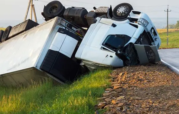 overturned truck at the side of the road
