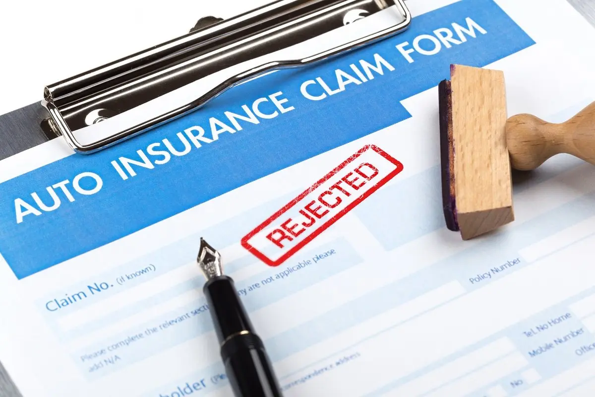 Auto insurance claim form stamped "REJECTED" with pen.