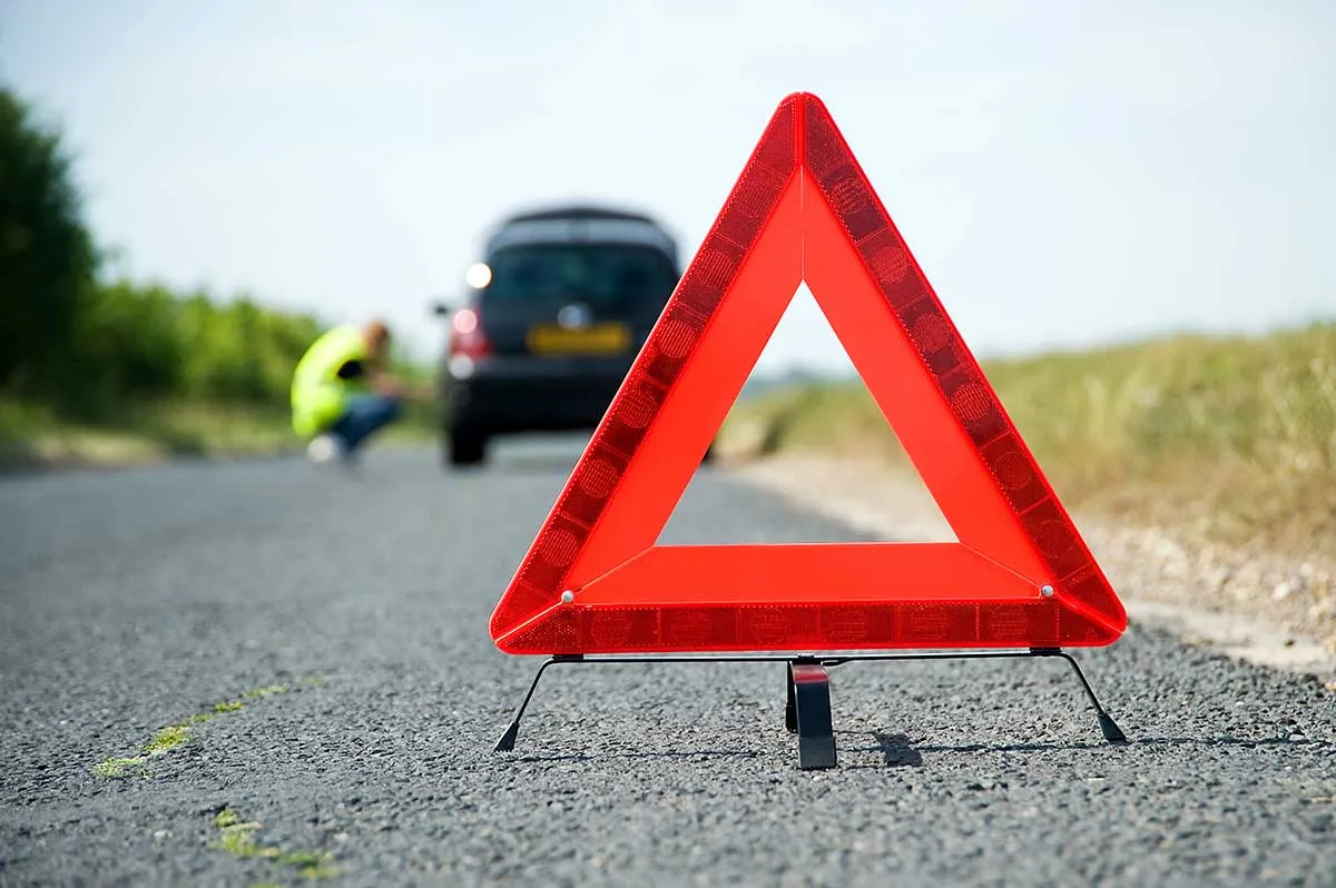 Bright red warning triangle on roadside.