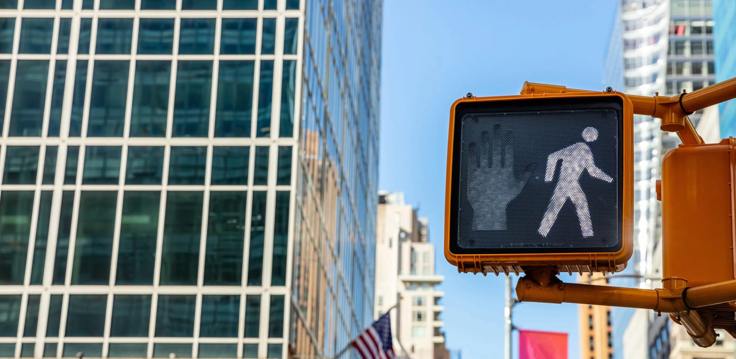 Urban crosswalk signal showing walk symbol.