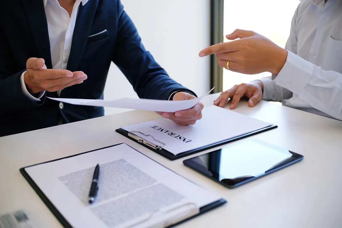 Two people reviewing insurance documents together.