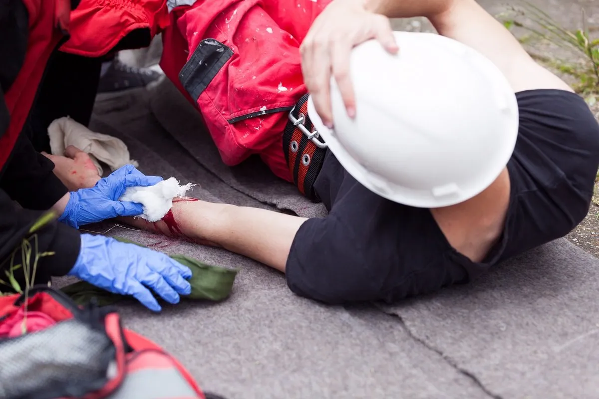 Injured worker receiving first aid treatment.