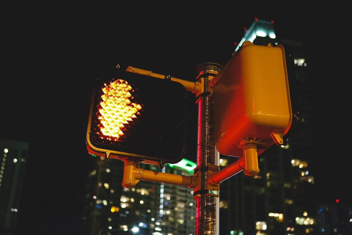Illuminated pedestrian stop signal at night.