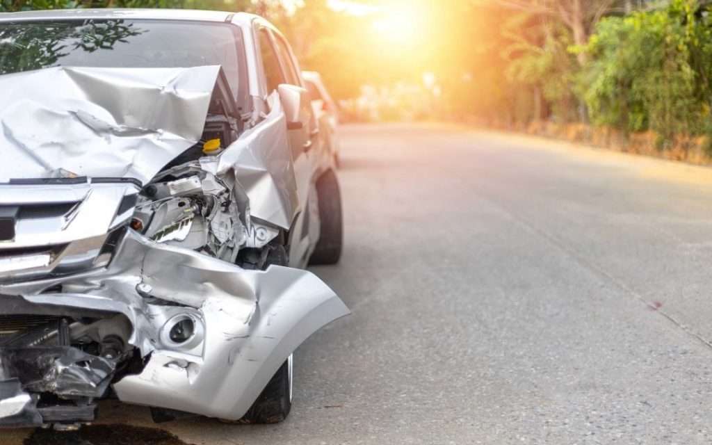 Silver SUV with severe front damage.