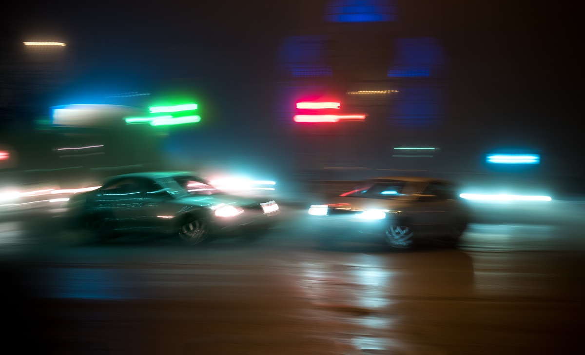 Two cars at night are about to crash head-on
