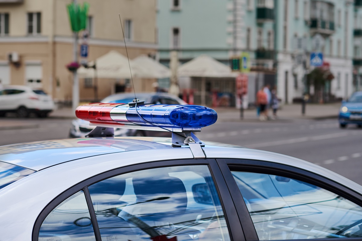 The roof and lights of a police car on a sunny day.
