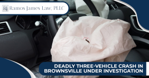 A close-up of the interior of a car with a broken windshield and deployed airbag.