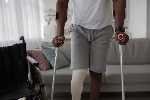 An injured man on cruches with one leg wrapped.