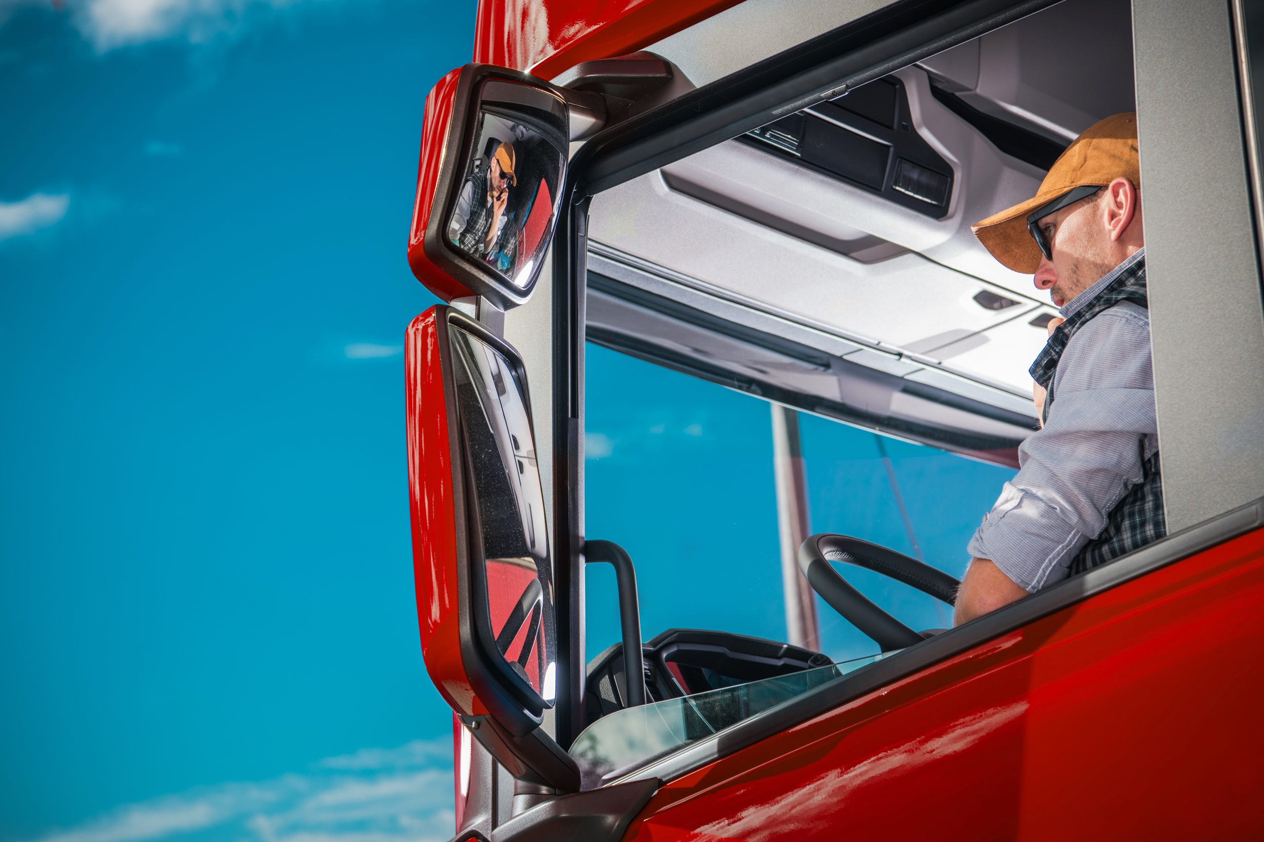 A truck driver sitting in a semi-truck