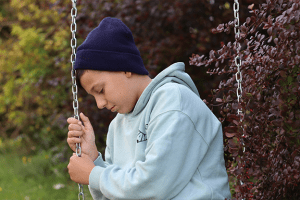 A sad boy on a swing